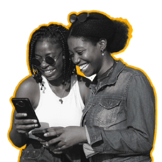 Two friends smiling as they make plans on their phones